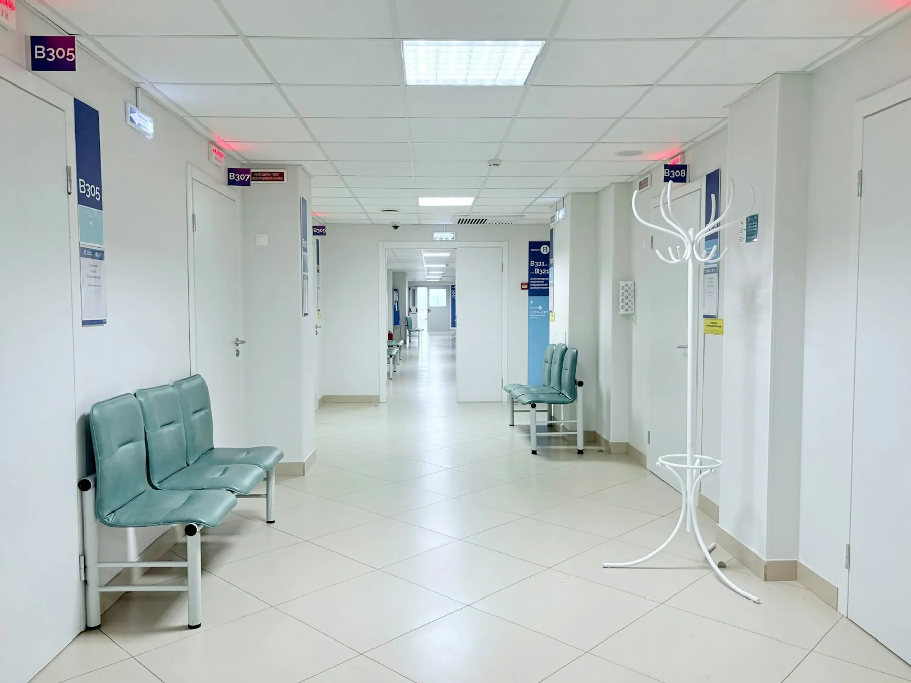 Empty hospital corridor with doors and seating